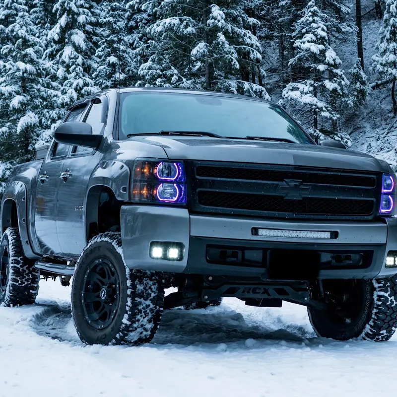 Silver Chevrolet truck with a 10-inch lift, parked in snow