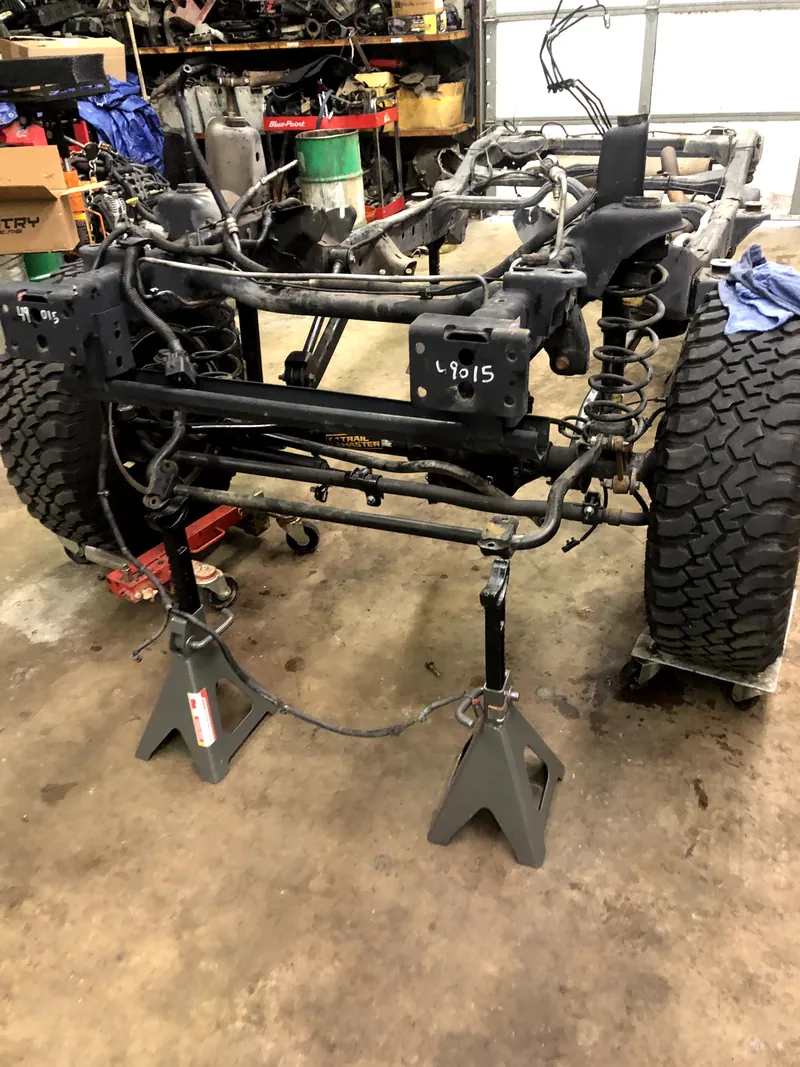 Exposed front axle and suspension during workshop repairs