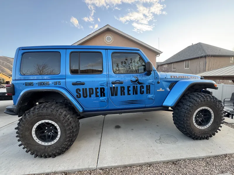 Blue Super Wrench Jeep parked outside