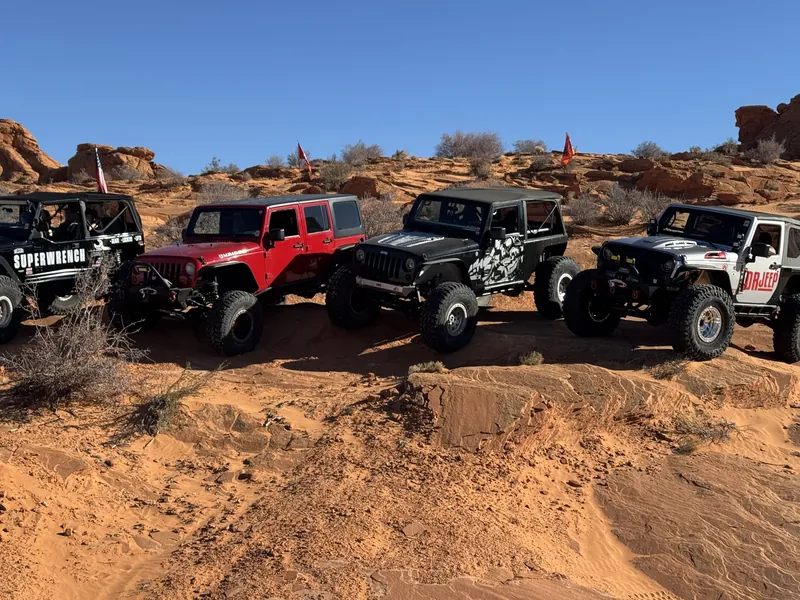 A lineup of Jeeps gathered on red sandstone